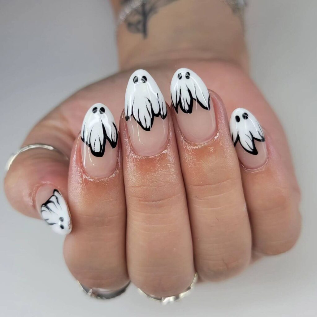 A variety of Halloween nail art designs, featuring ghost nails, pumpkin nails, and spider web nails with a spooky, festive look.