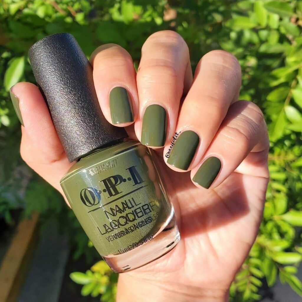 Chic olive green nails featuring gold foil accents and elegant, glossy finishes.