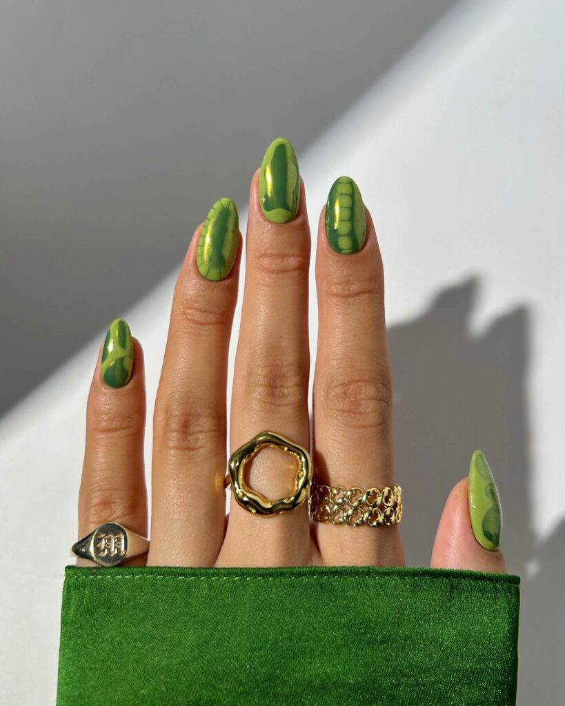 Chic olive green nails featuring gold foil accents and elegant, glossy finishes.