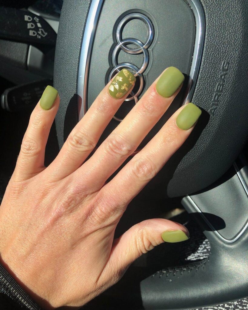 Chic olive green nails featuring gold foil accents and elegant, glossy finishes.