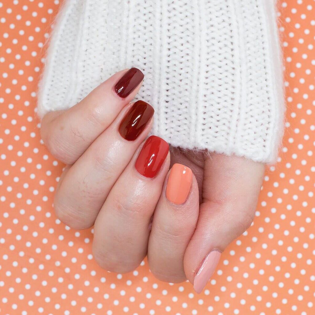 Close-up of warm-toned pumpkin spice nails with a fall-inspired design.