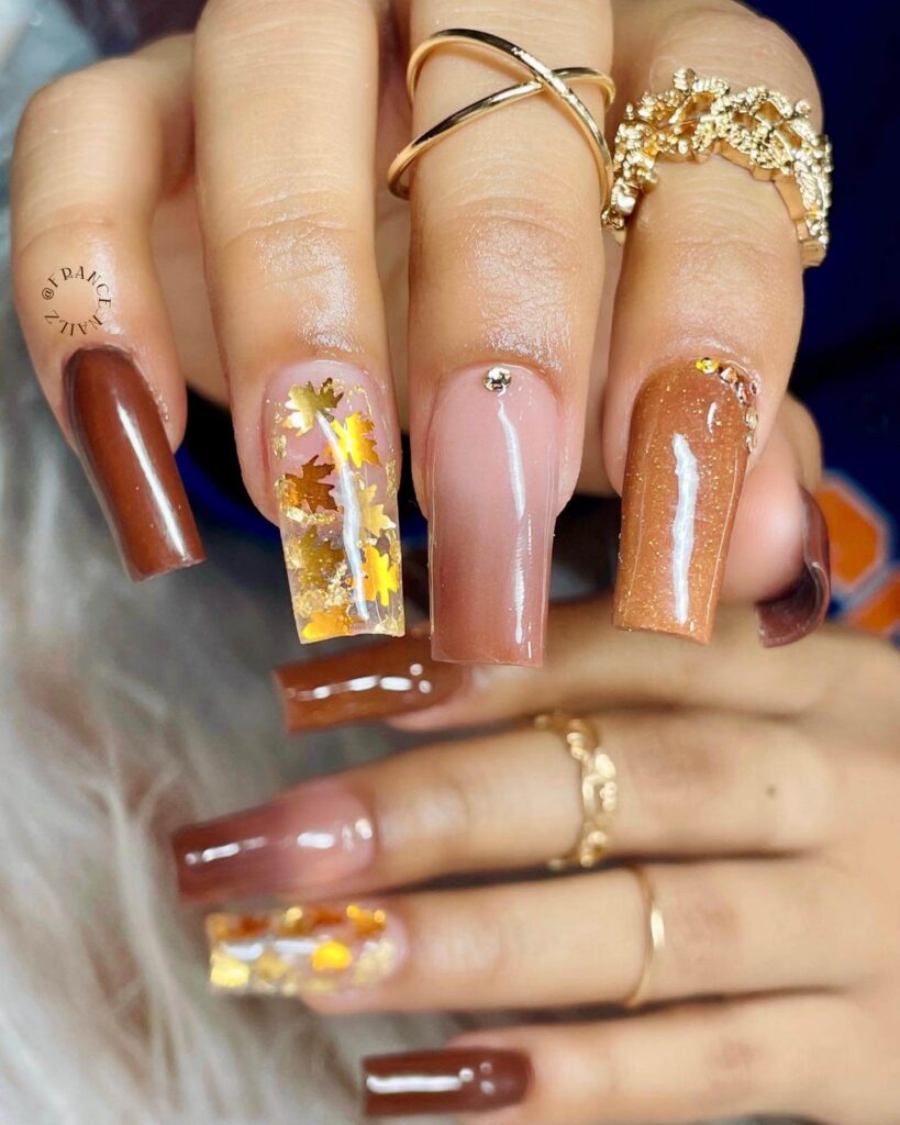 Close-up of warm-toned pumpkin spice nails with a fall-inspired design.