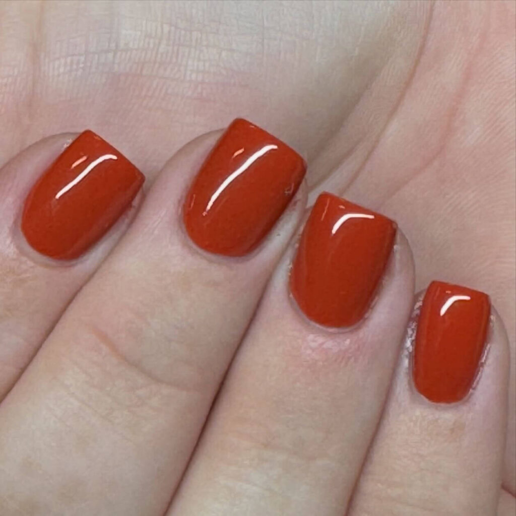 Close-up of warm-toned pumpkin spice nails with a fall-inspired design.