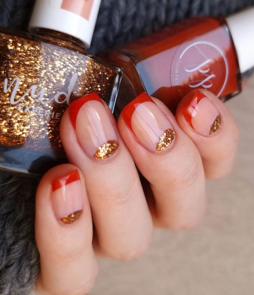 Close-up of warm-toned pumpkin spice nails with a fall-inspired design.