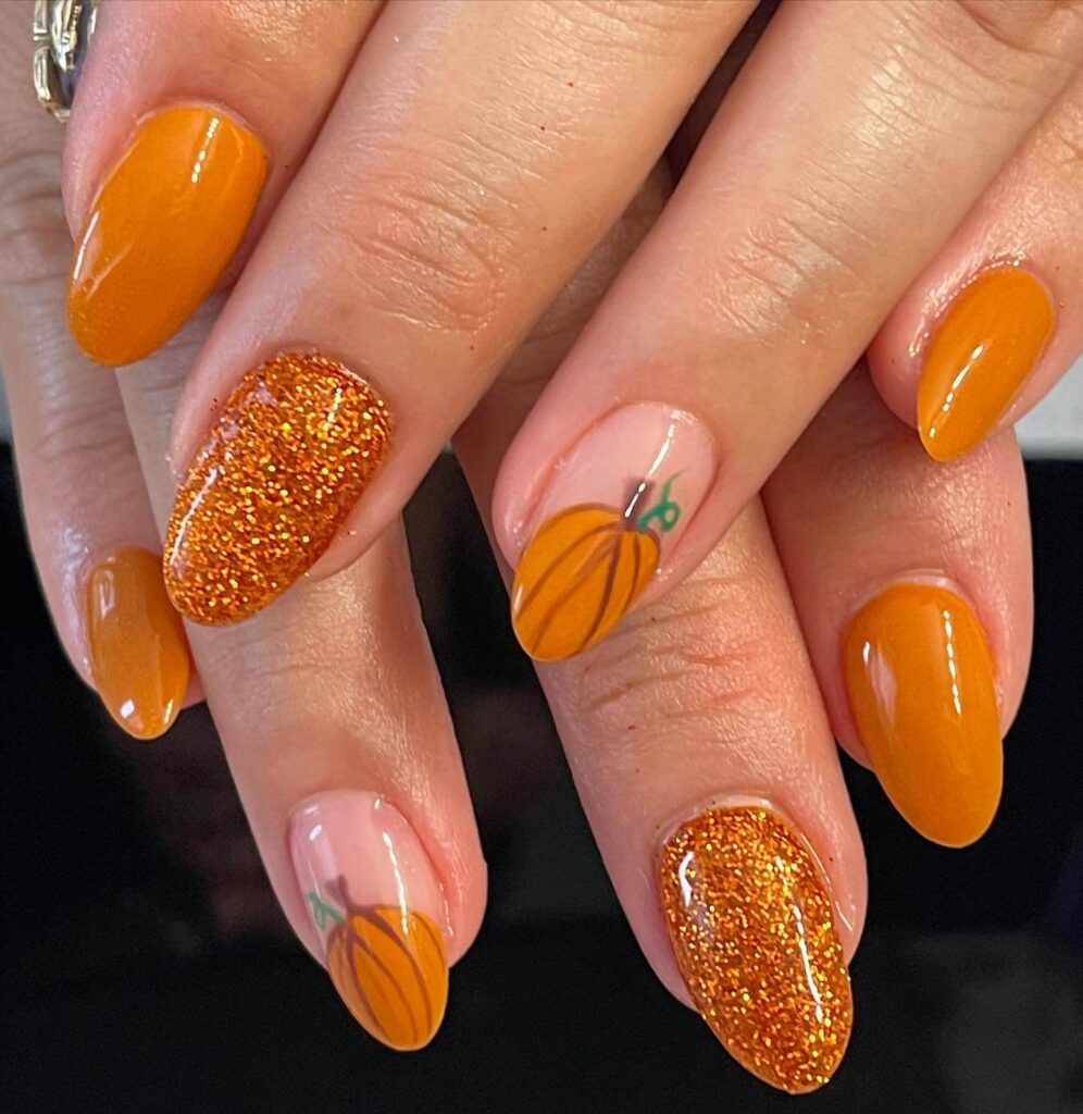 Close-up of warm-toned pumpkin spice nails with a fall-inspired design.