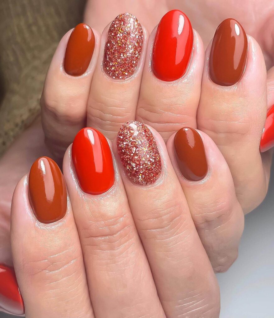 Close-up of warm-toned pumpkin spice nails with a fall-inspired design.