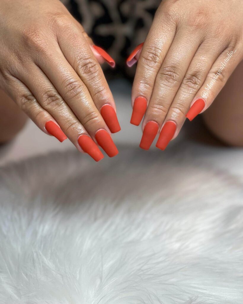 Close-up of warm-toned pumpkin spice nails with a fall-inspired design.