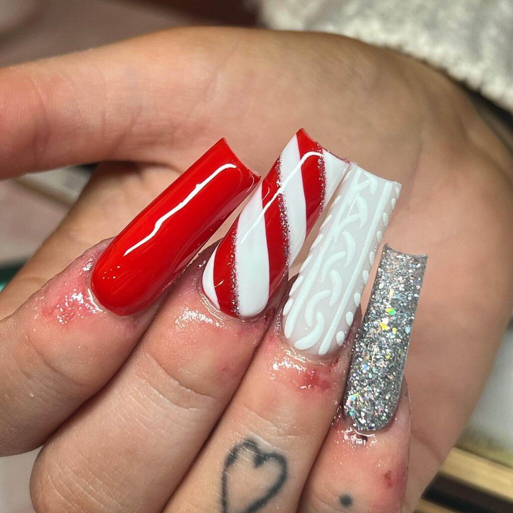 candy cane nails with red and white stripes and glitter accents, perfect for a festive holiday look.