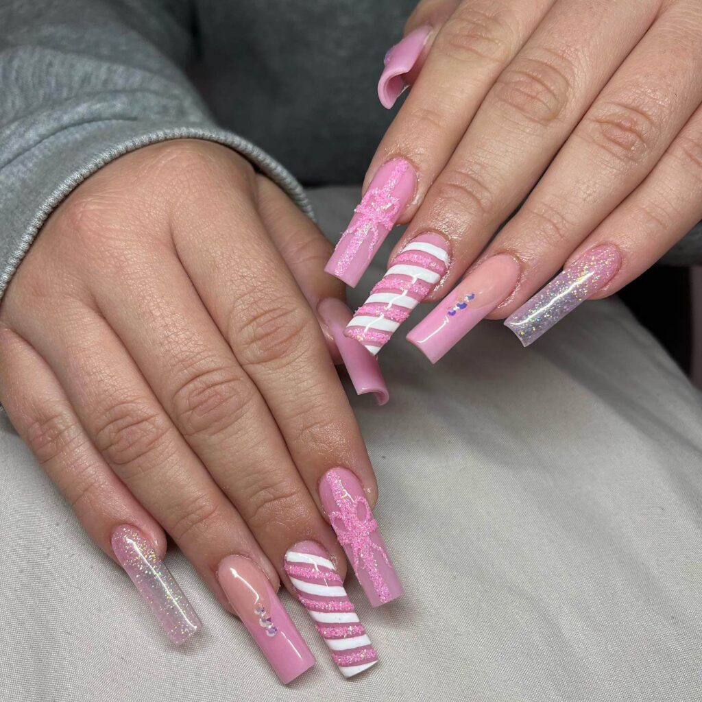 candy cane nails with red and white stripes and glitter accents, perfect for a festive holiday look.