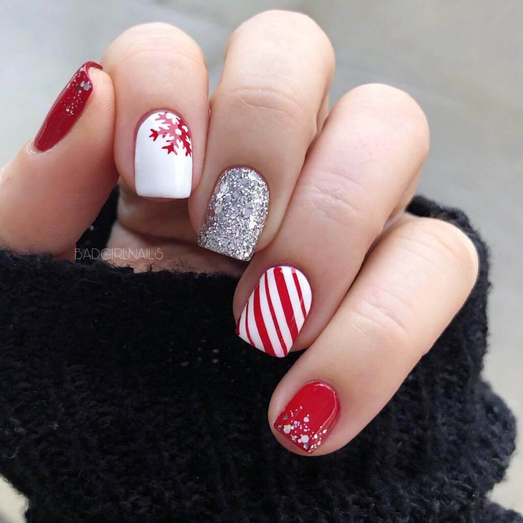 candy cane nails with red and white stripes and glitter accents, perfect for a festive holiday look.