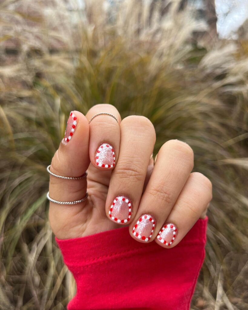 candy cane nails with red and white stripes and glitter accents, perfect for a festive holiday look.