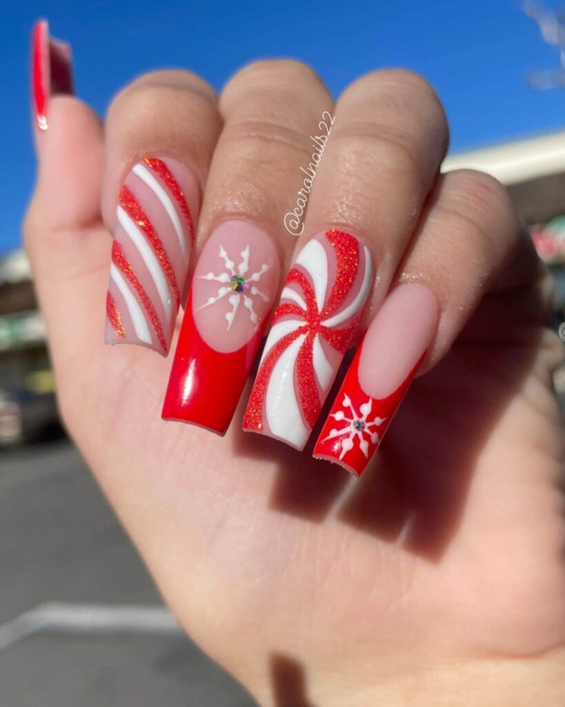 candy cane nails with red and white stripes and glitter accents, perfect for a festive holiday look.