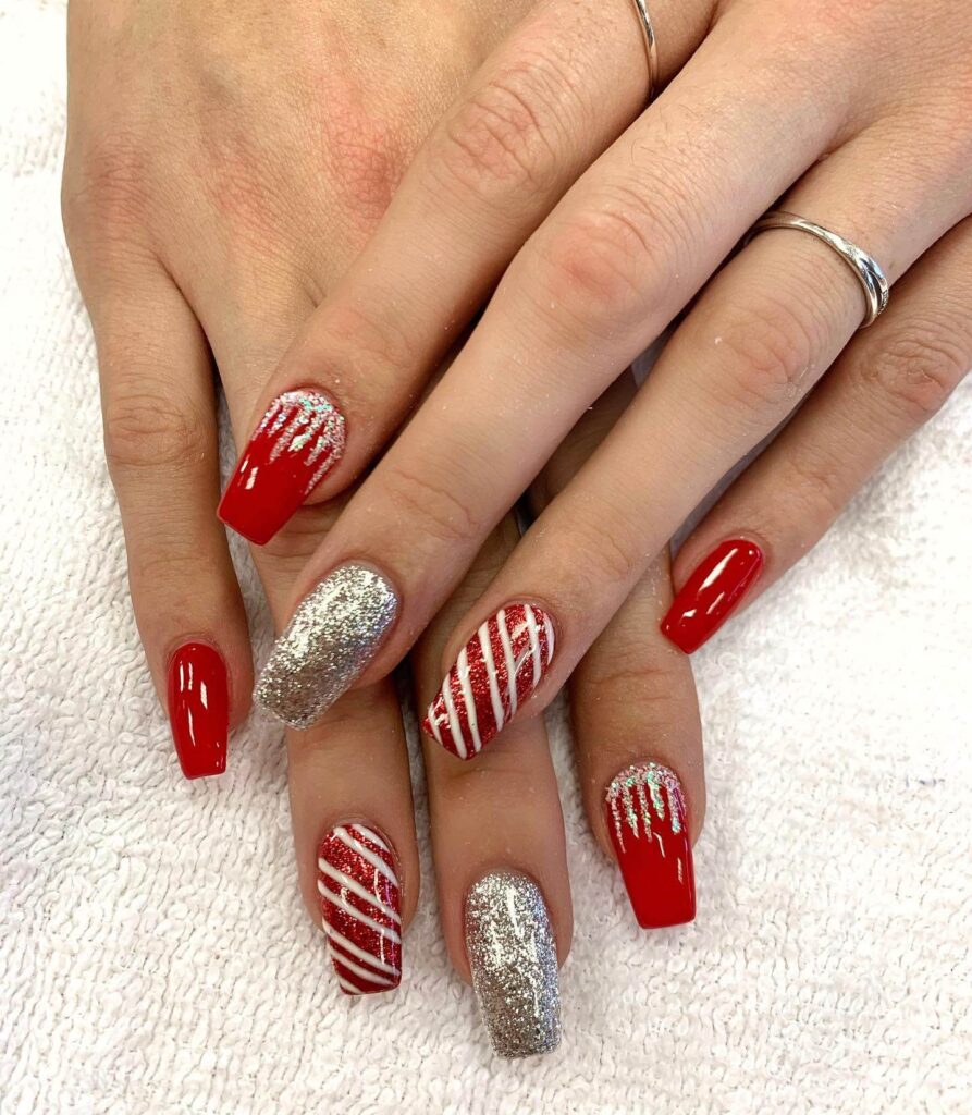 candy cane nails with red and white stripes and glitter accents, perfect for a festive holiday look.