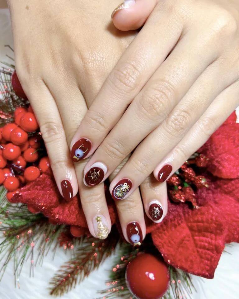 Festive Christmas nail designs featuring red and green nails with glitter accents, snowflakes, and holiday-themed nail art.