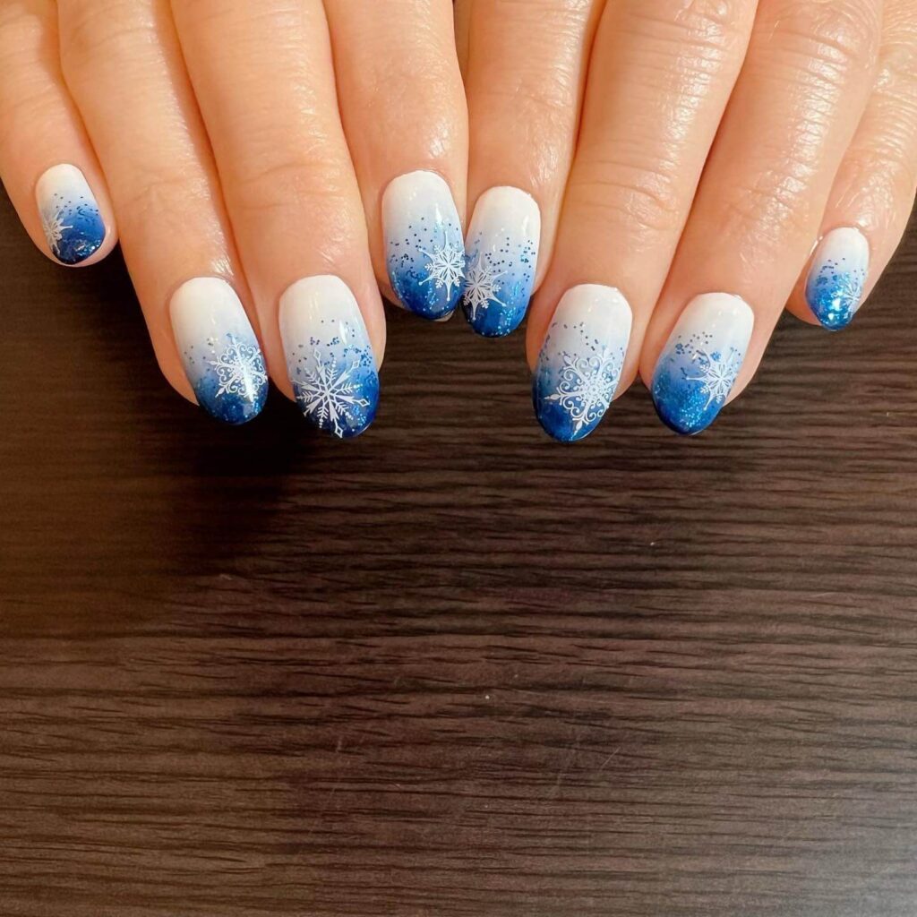 elegant winter nails with blue Christmas nails and delicate snow nail art, perfect for the festive season.